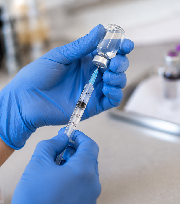 Gloved Hands Preparing Injection in TRT Replacement Therapy Clinic
